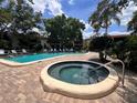 Community pool and spa with brick patio and lush landscaping at 6462 Wild Oak Bay Blvd # 247, Bradenton, FL 34210