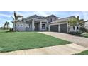 Attractive home featuring a lush green lawn, complemented by a paver driveway leading to the attached garage at 8007 Nevis Run, Bradenton, FL 34202