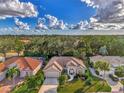High angle view of a single-Gathering home amidst lush greenery and similar properties at 114 Fieldstone Dr, Venice, FL 34292