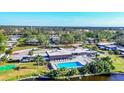 Aerial view of community pool, clubhouse, and lush landscaping at 1305 Glen Oaks E Dr # 130, Sarasota, FL 34232