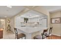 Efficient kitchen featuring white cabinets and breakfast bar at 1305 Glen Oaks E Dr # 130, Sarasota, FL 34232