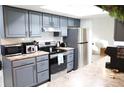 Modern kitchen with gray cabinets, stainless steel appliances, and a bright skylight at 1416 Glenmere Dr, Brandon, FL 33511