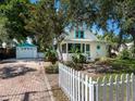 Charming home features a quaint white picket fence, complemented by a detached garage with matching trim details at 2724 Ashton Rd, Sarasota, FL 34231