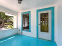 Enclosed porch features bright turquoise trim, with ample natural light and a refreshing beachy feel at 2724 Ashton Rd, Sarasota, FL 34231
