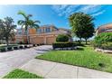 Exterior elevation of a home with paver driveway, lush lawn, and palm trees at 318 Winding Brook Ln # 104, Bradenton, FL 34212