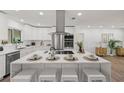 Modern white kitchen featuring stainless steel appliances, a large island with seating, and white cabinetry at 346 Suwanee Ave, Sarasota, FL 34243