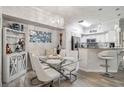 Bright dining area with glass table, white chairs, and a bar cabinet at 4106 Central Sarasota Pkwy # 1013, Sarasota, FL 34238