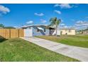 Charming light blue home with a screened porch, wooden and white fence, and large lawn at 5033 La Copa St, North Port, FL 34287