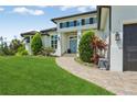Inviting home with a manicured lawn, stone pathway, and well-maintained landscape leading to a blue front door at 609 Colonial Bay Dr, Nokomis, FL 34275
