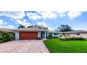 Well-maintained home featuring a brick driveway and lush lawn at 7331 Biltmore Dr, Sarasota, FL 34231