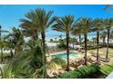 Inviting pool area with lounge chairs, umbrellas, and palm trees, overlooking the beach at 915 Seaside Dr # 613 Weeks 4-5, Sarasota, FL 34242