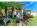 Inviting front entrance with a white door, ornate bench, and lush landscaping at 1605 21St W Ave, Palmetto, FL 34221