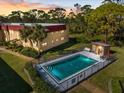 Community pool with fenced surround plus an adjacent cabana and seating against a backdrop of mature trees at 207 Rubens Dr # D, Nokomis, FL 34275