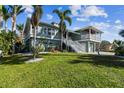 Two-story house with a large yard, palm trees, and a white staircase at 2127 Lusitania Dr, Sarasota, FL 34231