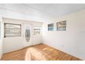 Bright sunroom with wood flooring, large windows, and a glass door at 3403 Overcup Oak Ter, Sarasota, FL 34237