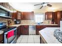 Kitchen with dark wood cabinets, stainless steel appliances, and tile countertops and backsplash at 5815 114Th N Ter, Pinellas Park, FL 33782