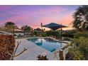 Inviting swimming pool area with tranquil water features and a picturesque sunset view at 609 Elba Dr, Nokomis, FL 34275