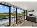 Relaxing screened porch overlooking the canal, pool, and lush tropical landscape at 609 Elba Dr, Nokomis, FL 34275