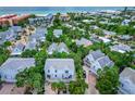 Stunning aerial view of a beach community with houses surrounded by lush green trees near the ocean at 6250 Holmes Blvd # 32, Holmes Beach, FL 34217
