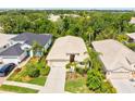 Aerial view of the home showing the beige tile roof, a well maintained lawn and mature landscaping at 8412 Whispering Woods Ct, Lakewood Ranch, FL 34202