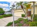 Charming single Gathering home showcasing a well-manicured lawn, a two-car garage, and mature landscaping at 8412 Whispering Woods Ct, Lakewood Ranch, FL 34202