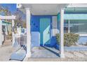 Charming blue home featuring a welcoming front door and porch with white pillars, plants and lattice work at 104 23Rd St, Bradenton Beach, FL 34217