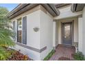 Front entrance with gray door, brick walkway, and landscaping at 1724 Hyssop Loop, North Port, FL 34289