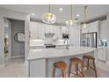 Modern kitchen with white cabinets, quartz countertops, and island at 1724 Hyssop Loop, North Port, FL 34289