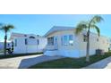 Front view of a tan mobile home with white trim and landscaping. Shows multiple mobile homes in a community at 3333 26Th E Ave # 1148, Bradenton, FL 34208