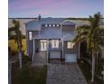 Gray two-story house with metal roof, large windows, and a paved driveway at 5531 2Nd Avenue W Cir, Palmetto, FL 34221