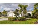 Well-maintained house with a landscaped front yard and palm trees at 7616 Alumni Trl, Sarasota, FL 34243