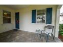 Front porch with blue shutters, a wreath on the door, and a seating area at 7616 Alumni Trl, Sarasota, FL 34243