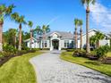Stunning curb appeal, featuring a large home with palm trees and a curving driveway at 8325 Lindrick Ln, Bradenton, FL 34202