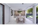 Covered patio with outdoor kitchen, dining area, and lounge chairs at 12198 Terkelsen Ave, Port Charlotte, FL 33981