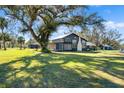 Charming farmhouse with large oak tree and expansive green lawn at 14900 Coker Gully Rd, Myakka City, FL 34251