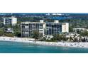 Beachfront condo building with white sand and ocean at 19 Whispering Sands Dr # 301, Sarasota, FL 34242