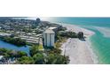 Wonderful aerial view of a white condo building situated on a white sandy beach with turquoise water at 19 Whispering Sands Dr # 301, Sarasota, FL 34242