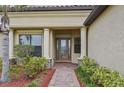 Front entry with columns, brick walkway, and landscaping at 20345 Reale Cir, Venice, FL 34293
