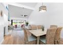 Bright dining area with wood table and wicker chairs, open to living room at 3405 Avenida Madera # B, Bradenton, FL 34210