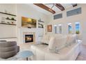 Bright and airy living room featuring a fireplace, high ceilings with wood beams and wall mounted television at 4742 Balboa Park Loop, Bradenton, FL 34211
