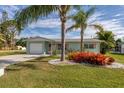 Charming single-story home with well-manicured lawn and tropical landscaping at 884 Stewart St, Englewood, FL 34223