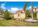 Attractive townhome featuring a red tile roof, green lawn, and mature landscaping at 9623 Sea Turtle Ter # 201, Bradenton, FL 34212