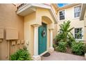 Charming entryway featuring a teal front door, elegant columns, and lush greenery at 9623 Sea Turtle Ter # 201, Bradenton, FL 34212