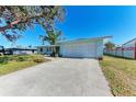 Light blue ranch home with white garage door and a large driveway at 1777 Pomelo Dr, Venice, FL 34293