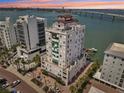 An aerial view of the condo building showing the waterfront location and sunset sky at 258 Golden Gate Pt # 801, Sarasota, FL 34236