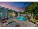 Inviting pool area with lounge chairs and tropical landscaping at 312 Hardin Ave, Anna Maria, FL 34216