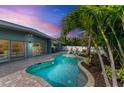 Freeform swimming pool with surrounding brick pavers at 312 Hardin Ave, Anna Maria, FL 34216