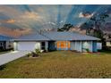 Single-story home with gray siding, white garage door, and landscaped lawn at 3215 Lake View Blvd, Port Charlotte, FL 33948