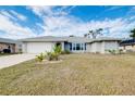 Single-story home with gray siding, white garage door, and landscaped lawn at 3215 Lake View Blvd, Port Charlotte, FL 33948