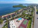 Aerial view of waterfront community with pool, tennis courts, and bay access at 4800 Gulf Of Mexico Dr # Ph 3, Longboat Key, FL 34228